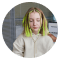 Young woman with closed eyes wearing a light green sweater.